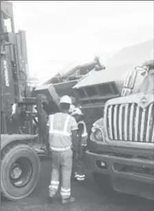  ??  ?? Workers implementi­ng a plan to reload the equipment on the truck.