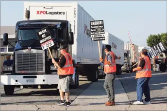  ?? Mark Boster / TNS ?? Port truck drivers picket at a XPO Logistics facility in Commerce, Calif., in 2017. A federal judge in California has given preliminar­y approval to two settlement­s of class-action lawsuits against XPO that would total nearly $30 million.