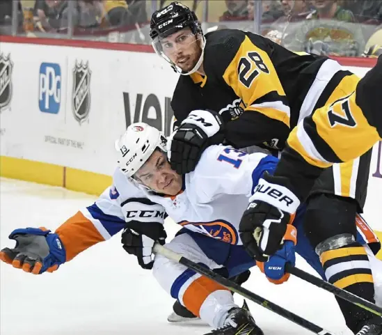  ?? Peter Diana/Post-Gazette ?? New defenseman Marcus Pettersson takes down New York’s Mathew Barzal Thursday night at PPG Paints Arena.