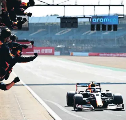  ?? MARK THOMPSON / GETTY ?? Els mecànics de Red Bull saluden Max Verstappen en el moment de guanyar a Silverston­e