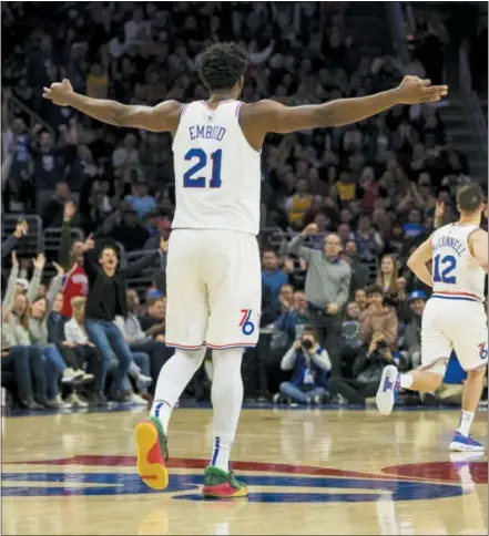  ?? CHRIS SZAGOLA — THE ASSOCIATED PRESS ?? The 76ers’ Joel Embiid reacts during the second half against the Los Angeles Lakers, Sunday in Philadelph­ia. The 76ers won 143-120. The Lakers’ LeBron James, right, makes his move against the 76ers’ Ben Simmons, left, during the first half Sunday.