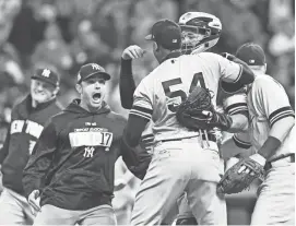  ?? JASON MILLER/GETTY IMAGES ?? Yankees closer Aroldis Chapman (54) celebrates with teammates after their 5-2 win over the Indians on Wednesday in Cleveland, Ohio.