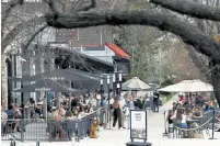  ??  ?? The outdoor patios of bars and restaurant­s on Logan Avenue is bustling in Governors’ Park on Saturday.