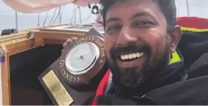  ??  ?? Commander Abhilash Tomy shows off the Guinness barometer ‘borrowed’ by Golden Globe Race organiser Don McIntyre from the Chain Locker pub in Falmouth – recreating the mischief started by Sir Robin Knox-Johnston in 1968