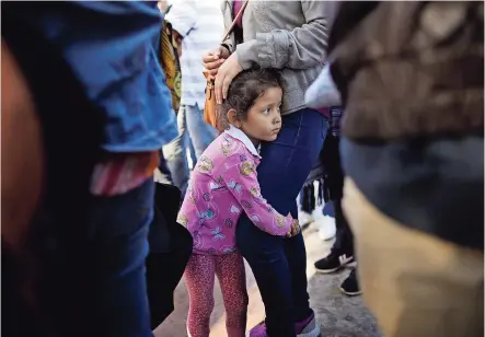  ??  ?? Una menor se abraza a las piernas de su madre migrante