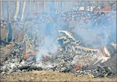  ?? [MUKHTAR KHAN/THE ASSOCIATED PRESS] ?? Kashmiri villagers gather near the wreckage of an Indian aircraft after it crashed Wednesday in the Budgam area, near Indiancont­rolled Kashmir.