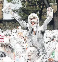  ??  ?? Top: Tom Abbott, 24, gets hosed down after the party. Above: all smiles during the foam fight at St Salvator’s Quad.