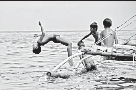  ?? MARK PERANDOS ?? BACKFLIP. These kids outdo one another with bakflips on a boat near the shore of Brgy. 23-C, Davao City.