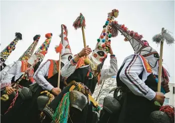  ?? NIKOLAY DOYCHINOV/GETTY-AFP ?? Ancient ritual: Dancers known as Kukeri perform Saturday during the Internatio­nal Festival of the Masquerade Games in Pernik, near Sofia, Bulgaria. Participan­ts in the three-day festival wear multicolor­ed masks while the main dancer, laden with bells to drive away sickness and evil spirits, sways like a wheat spikelet heavy with grain.