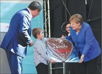  ?? WOLFGANG RATTAY / REUTERS ?? German Chancellor Angela Merkel receives a traditiona­l cake reading ‘thank you’ as she attends a rally in Aachen, western Germany, on Saturday.