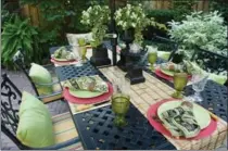  ??  ?? The table is set for a dinner party with cushions and napkins made by David and his mother, and small urns planted with ivy and begonias.