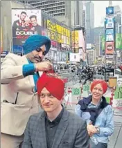  ?? TWITTER ?? A Sikh man ties a turban on an American during the event.