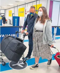  ?? Pictures: Shuttersto­ck/SNS. ?? Top: A man wearing a face mask is seen at La Malagueta beach in Spain where a new virus outbreak has caused the regional government to impose the obligatory use of face masks in outdoor places; above: more people are flying from Scottish airports.