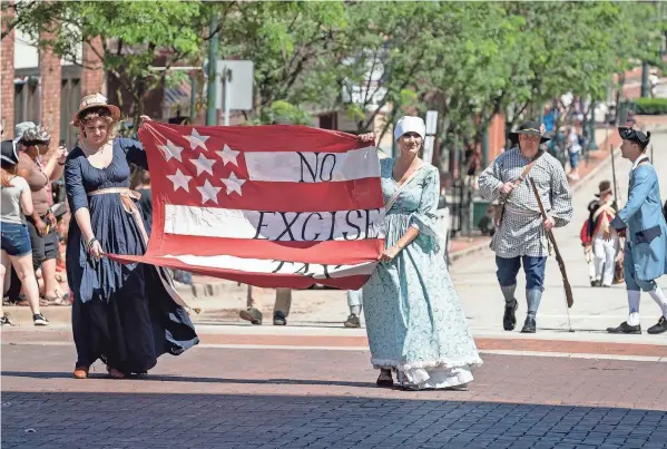  ?? COURTESY BRADFORD HOUSE HISTORICAL ASSOCIATIO­N ?? Reenactors carry a rebellion flag in the street during a previous festival.