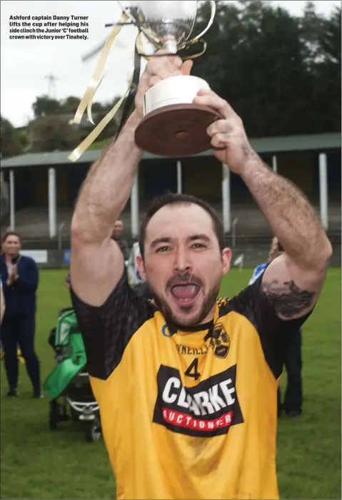  ??  ?? Ashford captain Danny Turner lifts the cup after helping his side clinch the Junior ‘C’ football crown with victory over Tinahely.