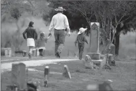  ?? ASSOCIATED PRESS ?? A FAMILY ARRIVES FOR a grave side service for Richard and Therese Rodriguez at the Sutherland Springs Cemetery, Saturday in Sutherland Springs, Texas. The Rodriguez couple were killed when a man opened fire inside the Sutherland Springs First Baptist...