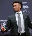  ??  ?? Oklahoma quarterbac­k Kyler Murray holds the Hesiman Trophy after winning the award in New York. On the day the A’s started spring training workouts, Murray said he will pursue a career in the NFL.