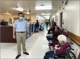  ?? DAVID A. LIEB — THE ASSOCIATED PRESS ?? Tim Corbin, left, the administra­tor of Truman Lake Manor, passes through the hallway of the nursing home in Lowry, Mo. The facility was cited in December for a violation of the federal vaccinatio­n requiremen­t for health care workers but subsequent­ly came into compliance. Corbin believes it’s time for the vaccinatio­n mandate to end.