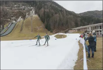  ?? PHOTOS BY ANDREA MANTOVANI — THE NEW YORK TIMES ?? Biathlon athletes train on a track of “farmed snow,” snow stored and packed from the previous winter and covered in reflective tarp, in the Bavarian village of Ruhpolding, Germany, on Jan. 12.