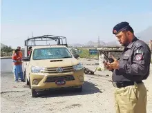  ?? Reuters ?? A police officer and rescue workers survey the site after a ■
suicide blast on paramilita­ry force checkpoint in Quetta.