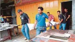  ??  ?? ANGGOTA polis mengangkat mayat lelaki maut akibat terkena simbahan asid cuka getah di Jalan Tembusu, Bandar Tiram.