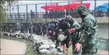  ?? PROVIDED TO CHINA DAILY ?? Troops from the People’s Armed Police Force’s Henan Provincial Command build flood barriers in Zhengzhou on Wednesday.