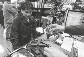  ?? RINGO H.W. CHIU/AP ?? BRIAN XIA, 44, PICKS UP HIS GUN AT A GUN STORE in Arcadia, Calif., on March 15, 2020. A federal appeals court has ruled that California’s ban on the sale of semiautoma­tic weapons to adults under age 21 is unconstitu­tional. A panel of the 9th U.S. Circuit Court of Appeals said Wednesday that the law violates the 2nd Amendment right to bear arms.