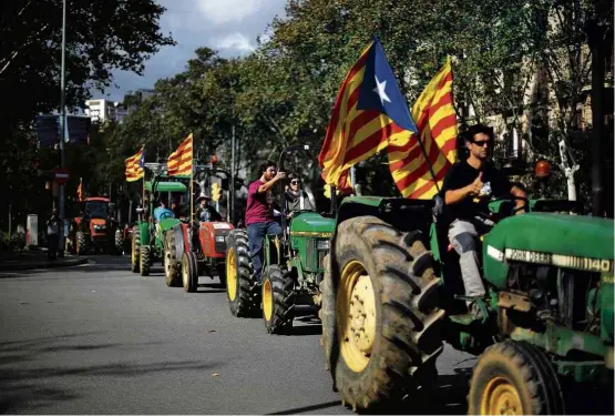  ?? Ivan Alvarado/Reuters ?? Comboio de tratores enfeitados com bandeiras da Catalunha chega a local de comício pró-independên­cia da região, em Barcelona, na terça-feira (10)