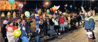  ??  ?? ●●After news of Josh’s death people gathered at the town hall to light candles and release balloons in his memory