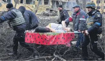  ?? AP Photo/Evgeniy Maloletka ?? ● An injured pregnant woman is carried from a damaged maternity hospital in Mariupol, Ukraine. The woman and her baby later died