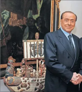  ??  ?? LA FIRMA. Momento en el que Silvio Berlusconi y Yonghong Li se hacen la fotografía trasla llegada del chino a la presidenci­a del Milán.