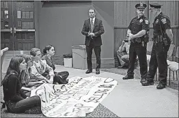  ?? [MINGRAN MA/FOR THE POST] ?? Some Ohio University students were charged with misdemeano­rs this past spring after they held a sit-in demonstrat­ion at a Board of Trustees meeting. They were demanding a wage freeze for university employees who earn more than $100, 000 a year to...