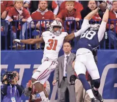  ?? MIKE DE SISTI / MILWAUKEE JOURNAL SENTINEL ?? Penn State tight end Mike Gesicki scores a touchdown over Wisconsin safety Lubern Figaro in the first half of the Big Ten title game.