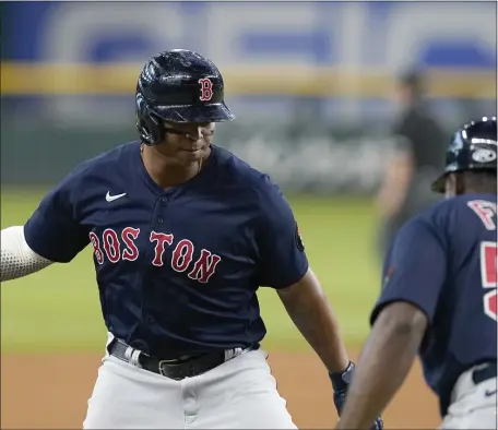  ?? AP ?? BEATING THE HEAT: Rafael Devers celebrates his two-run home run with third base coach Carlos Febles during the third inning against the Texas Rangers in Arlington, Texas, on Saturday night.