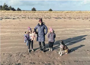  ?? ?? Heather Fegan, centre, with her daughters Rosie, left, and Anna, enjoyed playing on the beach with their family dog. An added benefit of a wintertime visit? Few people are around, giving them plenty of room to explore.