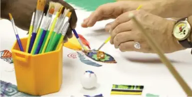  ?? MATT KELLY ?? Textile artist Apanaki Temitayo Minerve works with a client on a mosaic project at Workman Arts.