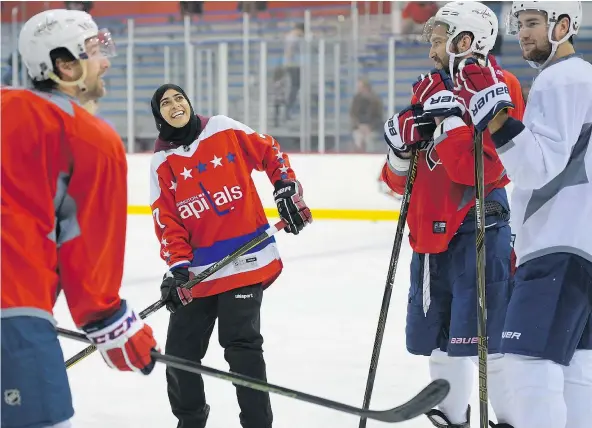  ?? — PHOTOS: JOHN MCDONNELL/THE WASHINGTON POST ?? Fatima Al Ali, a fan from the United Arab Emirates, was in Washington and hit the ice recently with Capitals players Justin Williams, left, Alex Ovechkin, centre right, and Tom Wilson after the team caught wind of her stickhandl­ing skills.