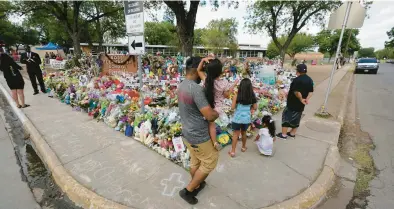  ?? ERIC GAY/AP ?? Mourners visit a memorial June 3 at Robb Elementary School in Uvalde, Texas, created to honor the victims killed in the recent school shooting,