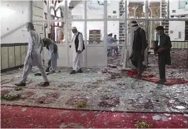  ??  ?? Afghan residents walk inside a damaged mosque after a suicide attack during Friday prayers in Gardez of Paktia province on Friday.