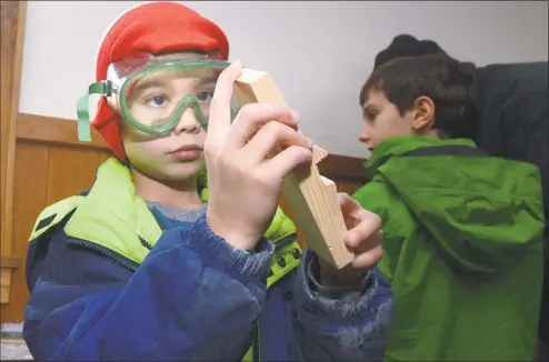  ?? Erik Trautmann / Hearst Connecticu­t Media ?? Cub Scout Anand Shah, 7, of Pack 2 feels for rough patches on his car during the Pinewood Derby Workshop at the Seton Scout Reservatio­n in Greenwich on Saturday.