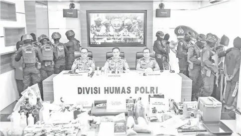  ?? — AFP photo ?? Indonesian police display terror suspects and the evidence recovered from them at a news conference in Jakarta.