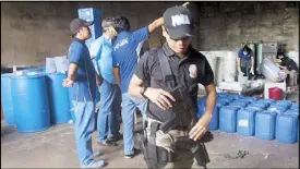  ?? RAYMUND CATINDIG ?? MEGA SHABU LAB: Police officers take an inventory of chemicals and equipment for manufactur­ing shabu following a raid on a warehouse owned by former Luna, Isabela mayor Manuel Tio in Cauayan, Isabela on Sunday. Police described the facility as a mega...