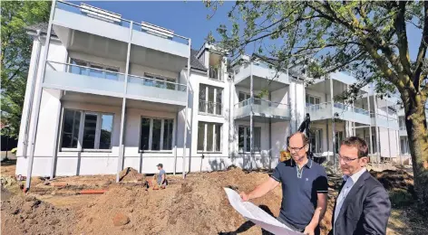  ?? RP-FOTO: MVO ?? Neue Balkone und große Fenster zum Garten: Markus Tönnissen (l.) und Michael Dorißen vor den GeWoGe-Wohnblocks an der Klombeckst­raße.