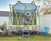  ?? BRAD DICKSON/THE NEW YORK TIMES ?? Twins, Nomi and Silas Effron, 8, play on the new trampoline their parents bought as the family plans for a summer spent mostly in their New York backyard.