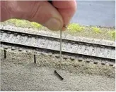  ??  ?? Above: If the top surface of your layout is soft, such as a piece of foam or cork, you can use a Foam Nail to push a hole in the surface to take a fence post, bollard, lamppost or tree.