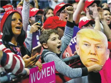  ?? CAROLYN KASTER/ASSOCIATED PRESS ?? James Crockett, 10, holds a mask of President Donald Trump and cheers as he arrives Monday for a rally at Allen County War Memorial Coliseum in Fort Wayne, Ind. Trump has generated overflow crowds of red-hatted supporters wherever he has gone in the final days of the campaign.