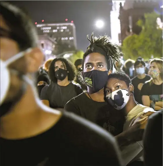  ??  ?? MASKED demonstrat­ors were a common sight in U.S. cities in a year of protest over racial justice issues. Above, protesters gathered in downtown L.A. after a grand jury