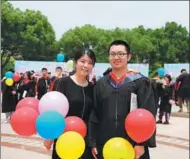  ?? PROVIDED TO CHINA DAILY ?? Xu Yiding, now a freshman at Fudan University, poses for a photo with a former teacher, Ma Ran, at his high school graduation ceremony this year.