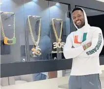  ?? VIA TRAVIS WILLIAMS/TWITTER ?? New Hurricanes inside linebacker­s coach Travis Williams poses with past UM turnover chains.