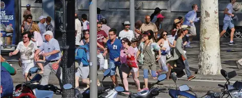  ?? AP ?? Panik und Chaos: Passanten auf der Flaniermei­le La Rambla versuchen sich in Sicherheit zu bringen.